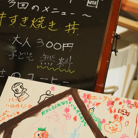 すき焼き丼のメニューを書いた黒板と、子どもたちが描いたハロウィンの絵